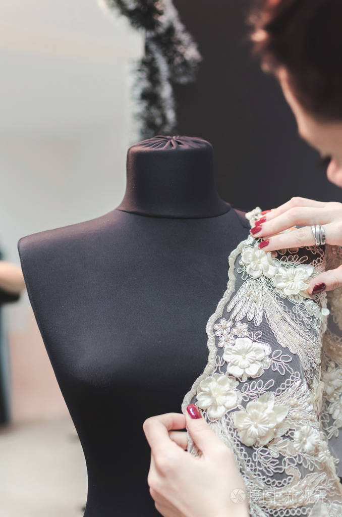 在裁缝店工作室工作的女时装设计师