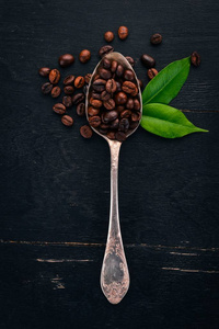 咖啡豆。 在勺子上躺在木制的背景上。 上面的风景。 复制空间。