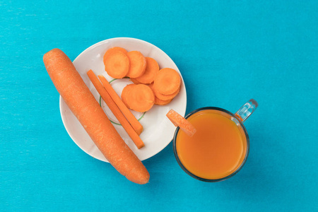 胡萝卜汁在一个蓝色的背景玻璃, 顶部的看法。健康饮食饮食的概念
