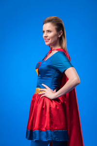 穿着超级英雄服装的美丽女人站在蓝边的秋明波旁边