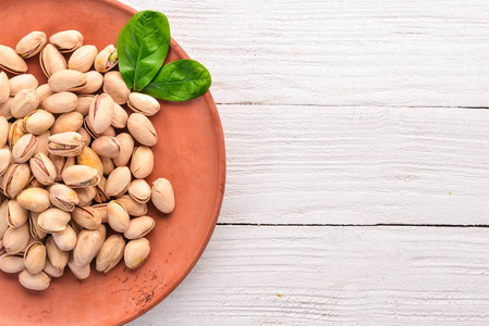 白色木制背景上的开心果坚果. 健康的零食. 上面的风景.