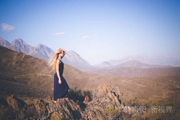 美丽的金发女郎站在山上欣赏风景照片-正版商用图片113b16-摄图新视界