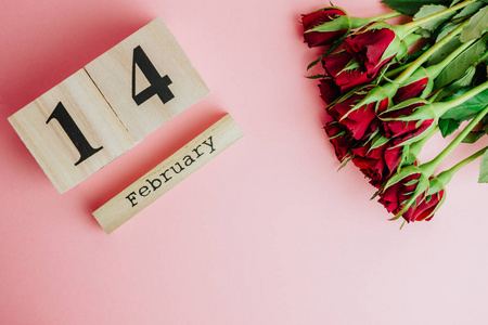 圣瓦伦廷斯日最小概念粉红色背景与复制空间。 2月14日的红玫瑰和木雪松