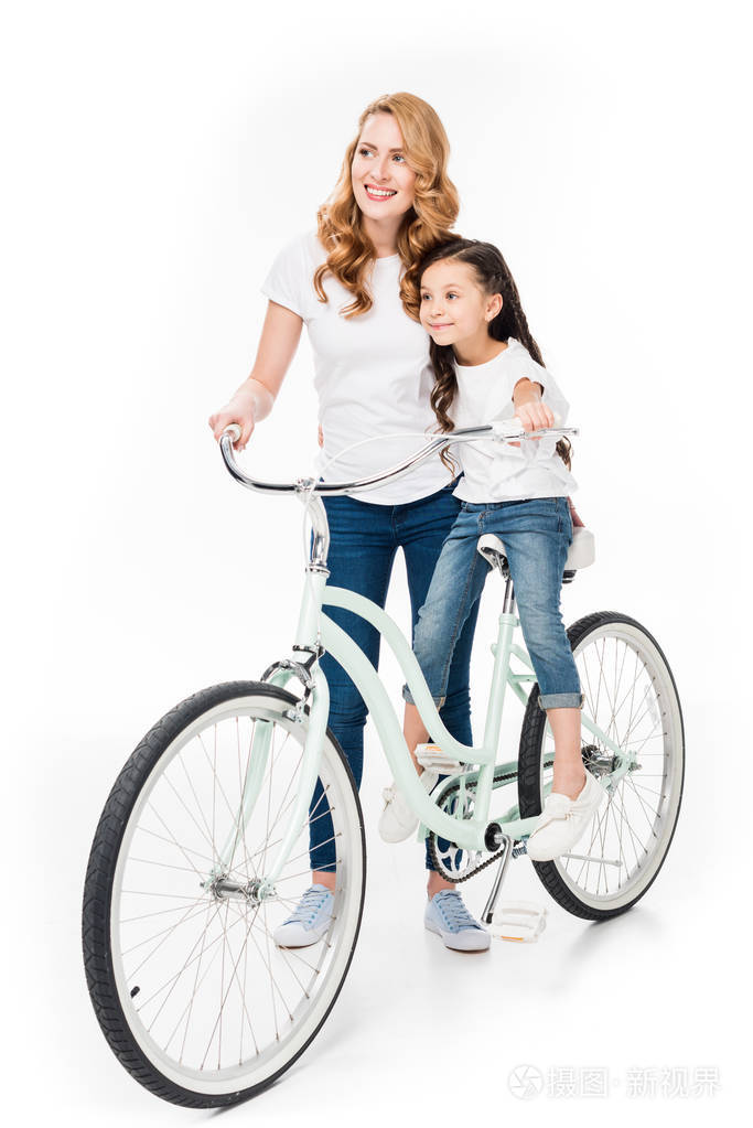 微笑的女人和女儿骑着复古自行车，与世隔绝的白色