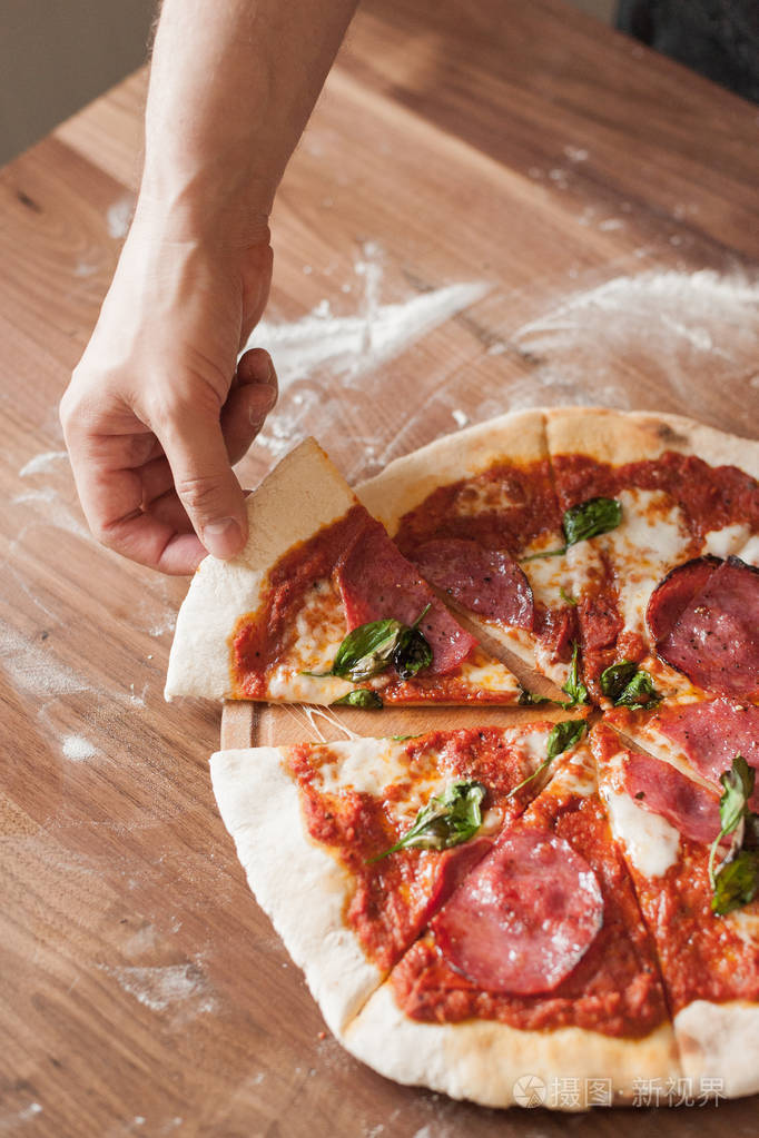 shandtakesapieceofpizzawithtomatopastecheesesalamijpg