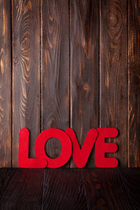情人节贺卡与爱的词在木制背景。 空间