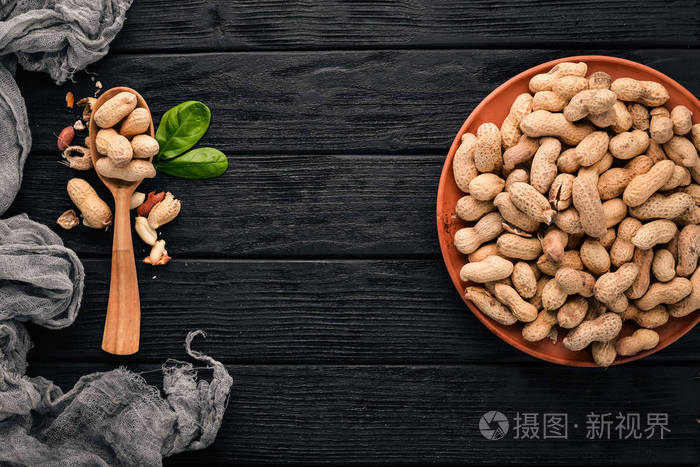 黑色木制背景上的花生. 健康的零食. 上面的风景. 免费的文本空间.