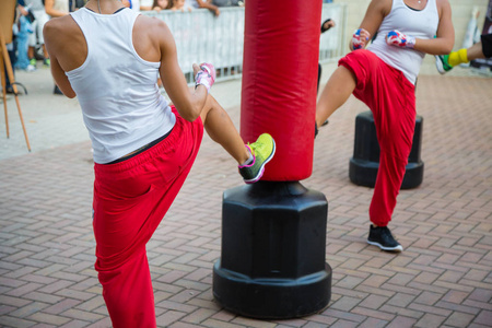 年轻女孩在健身房 拳击锻炼与红色冲袋