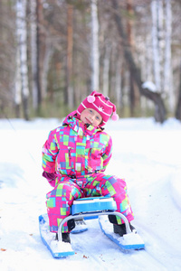 快乐的女孩在冬天的雪林里打雪球