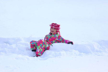 快乐的女孩躺在雪地里
