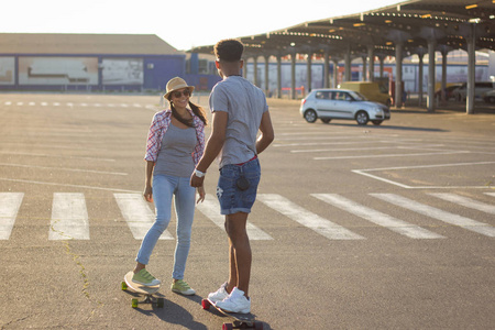 幸福的年轻夫妇有滑板的概念，幸福，爱和青春。