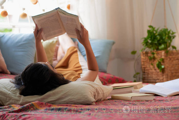 躺在床上看书的女人享受周末