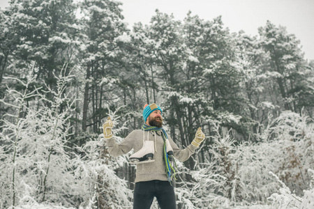 穿热夹克的人冬天胡须很暖和。 温度冻结，寒冷，突然下雪。 有胡子的人在雪地森林里带着冰鞋。 冬季运动和休息圣诞节。 冬天的护肤和