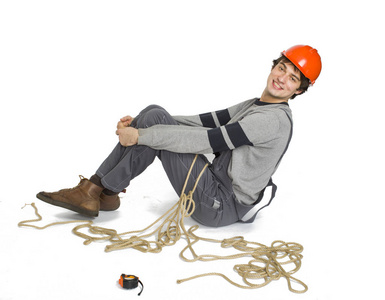 一个年轻的工人在灰色制服绑在白色隔离背景的绳子