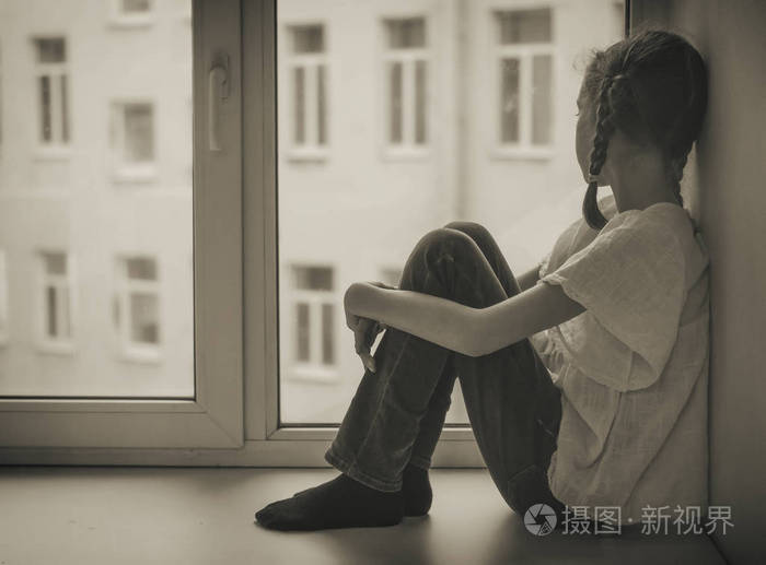 可怜的小女孩坐在窗边黑白
