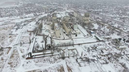 粮食码头在冬季。雪覆盖在农村地区的谷物升降机。一座建筑的干燥 储粮