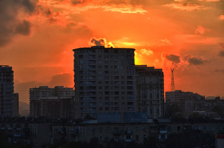 夕阳下的建筑物, 只是地平线上显示丰富多彩的夜晚阿塞拜疆巴库。美丽的剪影日落在巴库城市阿塞拜疆。商业区的建筑酒店和居民景观