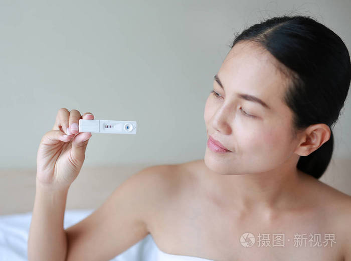 测试装置显示怀孕阳性的快乐女人照片-正版商用图片114933-摄图新视界