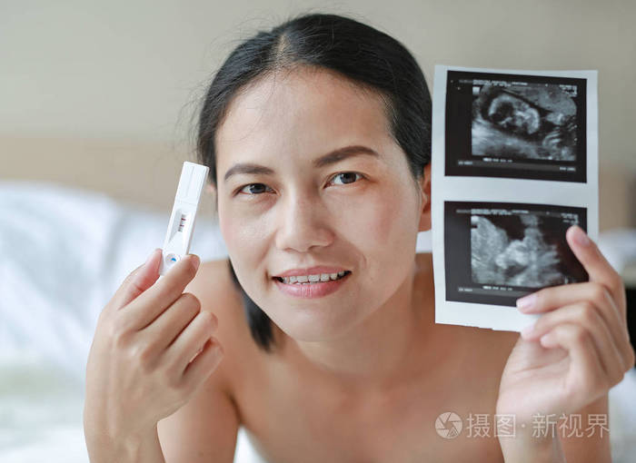 测试装置显示怀孕阳性的快乐女人照片-正版商用图片1149ap-摄图新视界