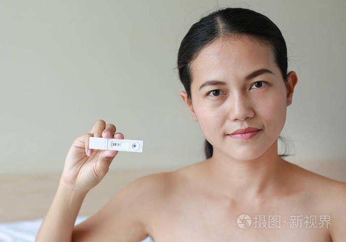 测试装置显示怀孕阳性的快乐女人照片-正版商用图片114aqz-摄图新视界