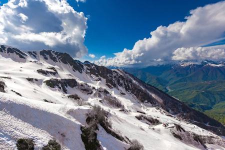 一个美丽的山坡，春天里有解冻的雪，阳光明媚，光线像星星，蓝天白云。