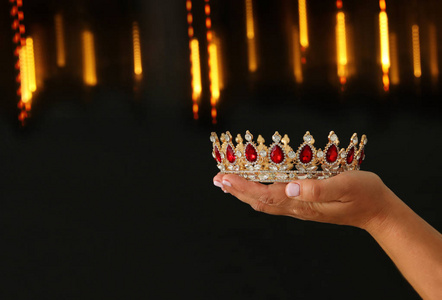 s hand holding a crown for show victory or winning first place o