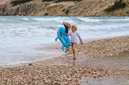 美丽的金发女孩在克罗地亚海岸的岩石海滩上玩得很开心照片