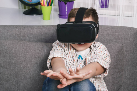 男孩在室内玩虚拟现实眼镜。数字虚拟现实设备