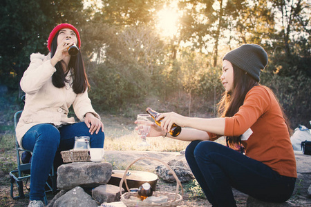 快乐的亚洲女人在自然冬季露营，放松时间度假概念旅行，选择性和柔和的焦点，时髦的风格