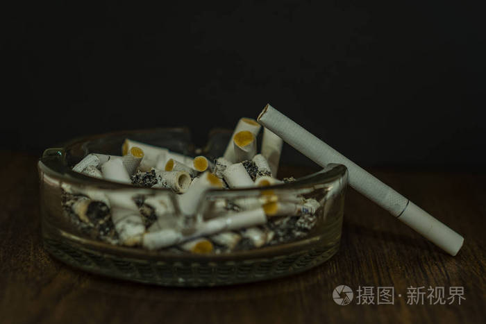 烟头在一个玻璃烟灰缸.一支烟不亮