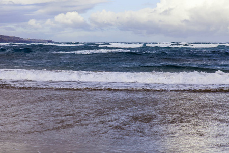 如画的波浪在海浪中冲刷海滨的沙滩。