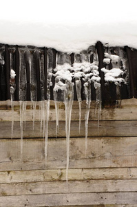 冰柱在意大利冬季白云岩的阿尔平小屋的屋顶上。