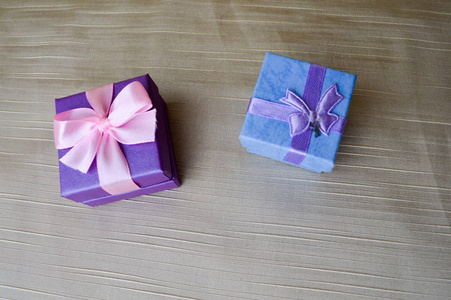 礼物美丽的节日盒子，蓝色和紫色，粉红色的蝴蝶和米色背景。