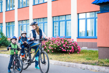 骑自行车上班，母亲与快乐的孩子骑自行车在户外的家庭