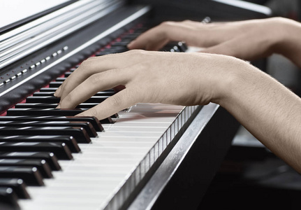 木制黑色钢琴与一个音乐家的键盘和女性手, 与一个模糊的背景
