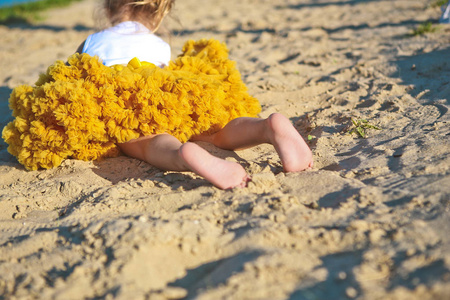 裙子黄色茂盛的小女孩沙子海滩脚脚跟照片