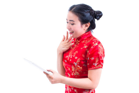 美丽的亚洲年轻女子的肖像穿着中国礼服传统的旗袍或旗袍使用现代数字平板与开放的嘴。震惊面部表情惊讶, 数字在线, 技术