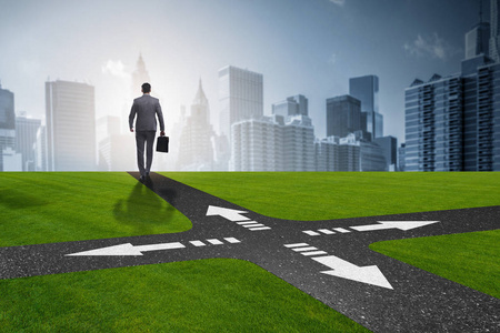 不确定概念交叉路口的年轻商人照片