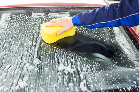 s Hand Cleaning Car Windshield With Sponge At Service Station