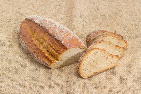 褐色面包与整个发芽的麦子五谷在麻布