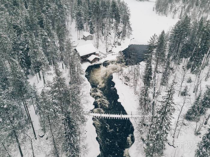 在奥兰卡国家公园的一个美丽的白雪皑皑的冬季景色的冰冷的河流鸟瞰。芬兰