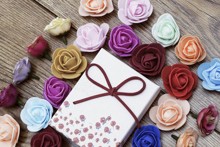 情人节的象征。礼品盒与小组玫瑰在木桌上。顶部视图