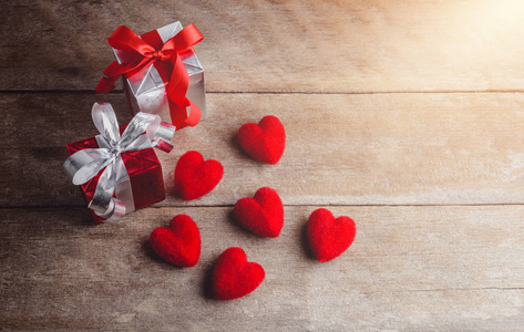 红色心脏和礼物箱子在木背景