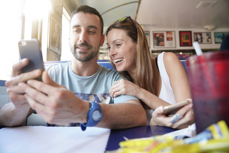 年轻夫妇在快餐店连接智能手机