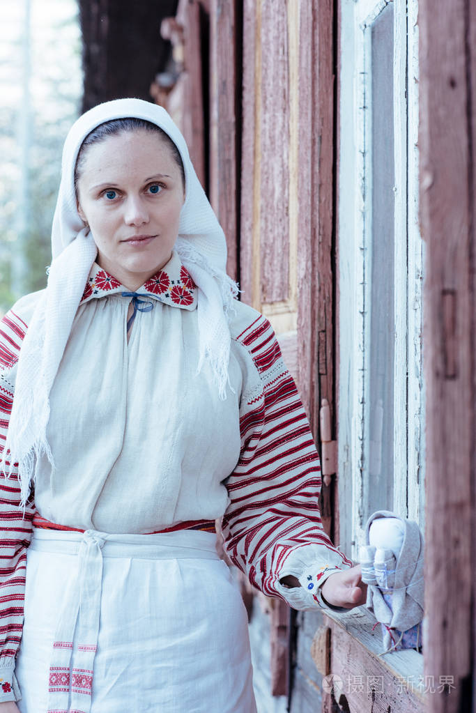 穿着斯拉夫民族服装和小偶像的幸福女人的肖像