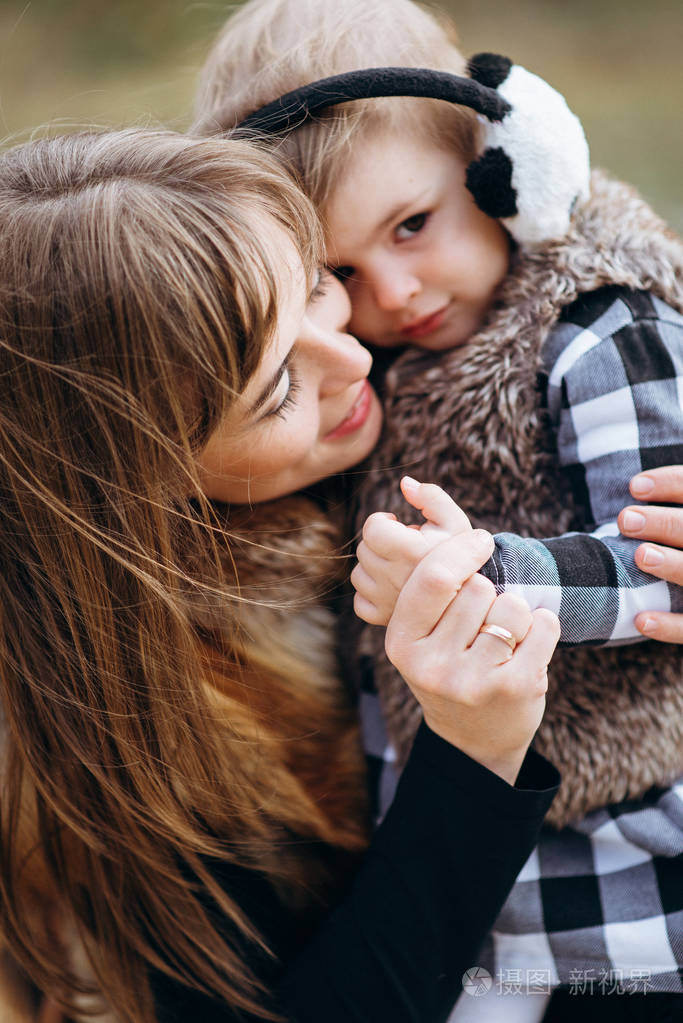 妈妈微笑着拥抱女儿的近景