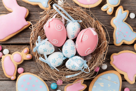 复活节姜饼饼干和鸡蛋在木桌上。 五颜六色的兔子。 顶部视图