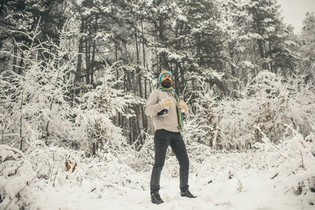 冬季运动和休息圣诞节。 有胡子的人在雪地森林里带着冰鞋。 穿热夹克的人冬天胡须很暖和。 温度冻结，寒冷，突然下雪。 冬天的护肤和