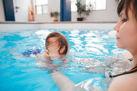 婴儿在水里潜水. 健康活跃的生活方式. 家庭活动和早期发展概念照片