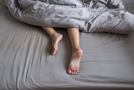 光着脚,醒来后懒洋洋地躺在床上照片